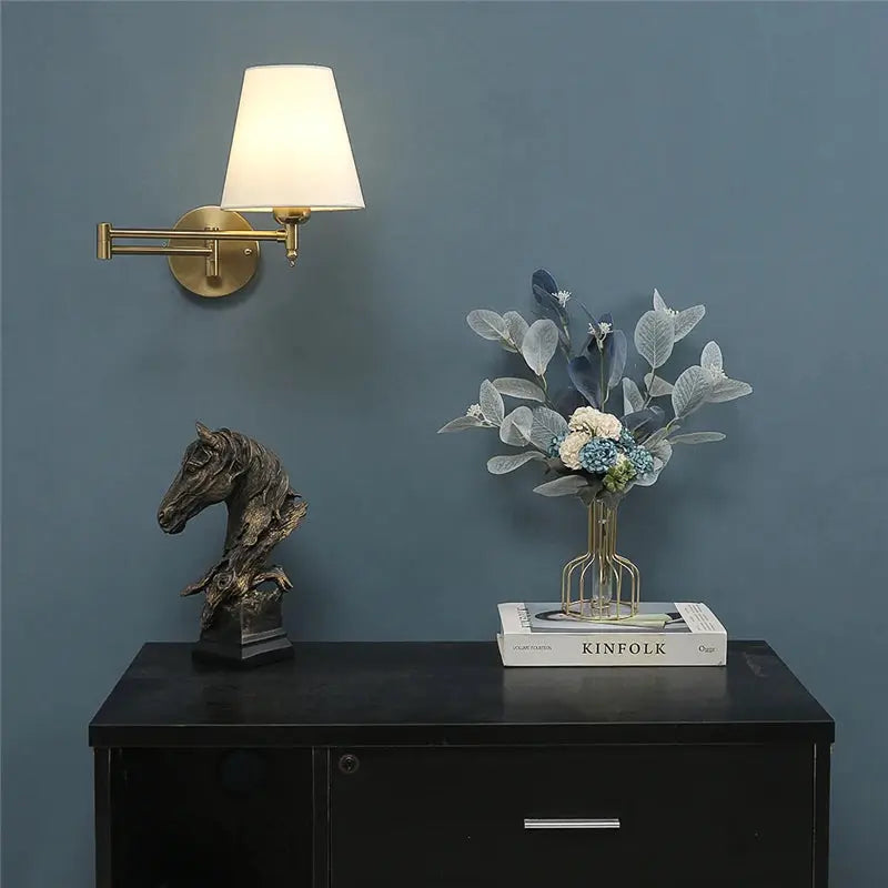 Simples Market Nordic adjustable folding wall lamp with rotating rocker arm, brass finish and white shade on blue wall.