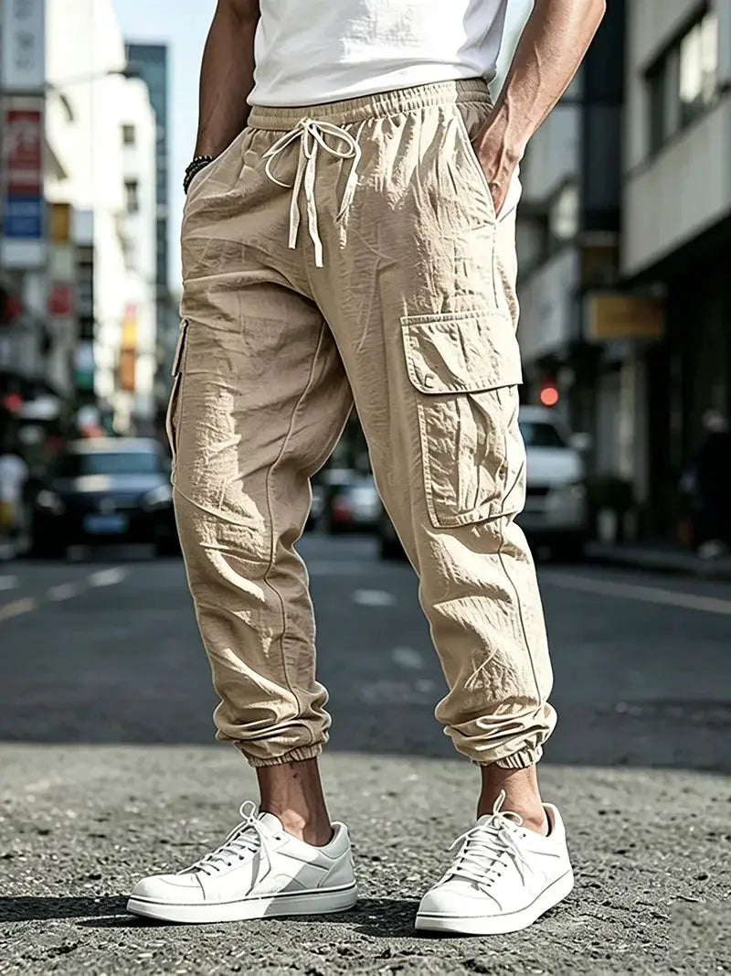 Men's cargo jogger pants in beige cotton linen blend with elastic waist, drawstring, cargo pockets, elastic cuffs.