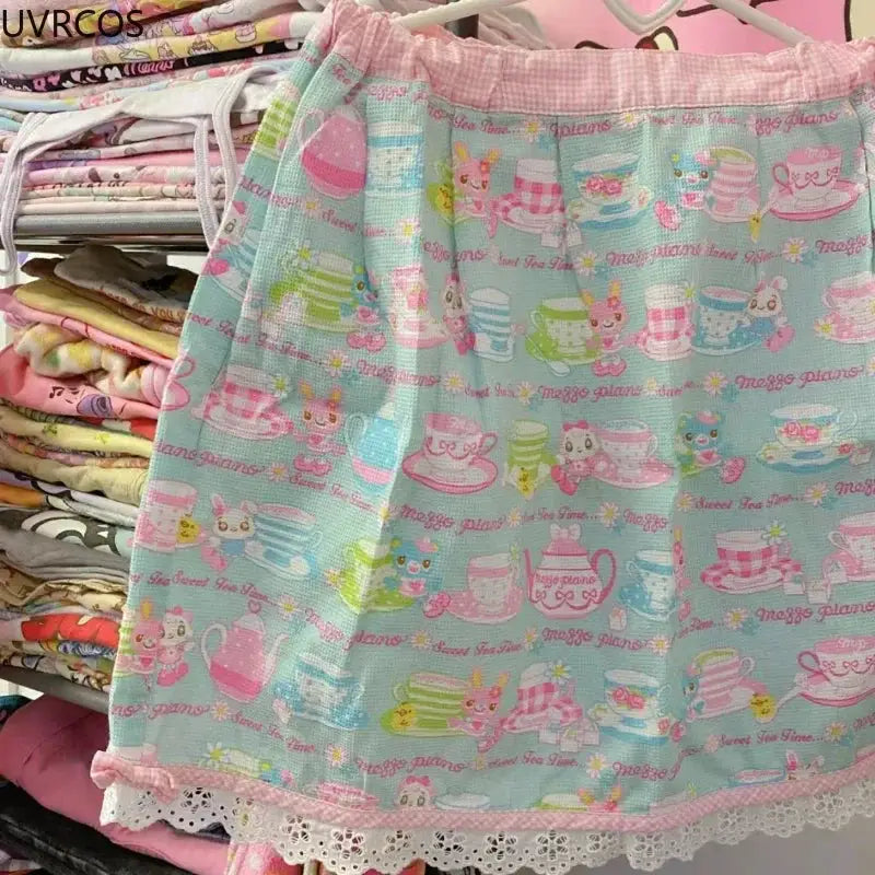 Pastel blue mini pleated skirt with cake and teacup print, lace-trim hem, kawaii lolita style.