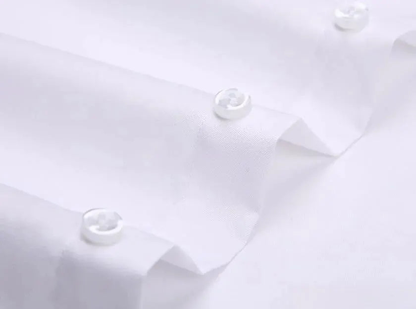 Men's white formal shirt close-up with buttoned cuffs and smooth fabric texture