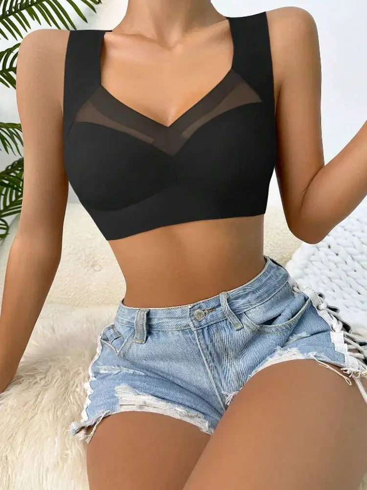 Women's black seamless bralette with mesh V-neck and wide straps, shown with denim shorts