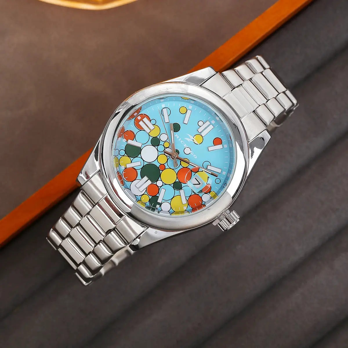 Classic men's stainless steel wristwatch with a round blue dial featuring colorful confetti patterns.