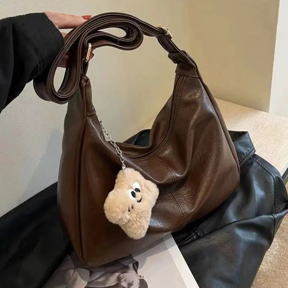 Brown PU leather slouchy shoulder bag with large capacity, retro hobo tote style, featuring a plush teddy keychain.
