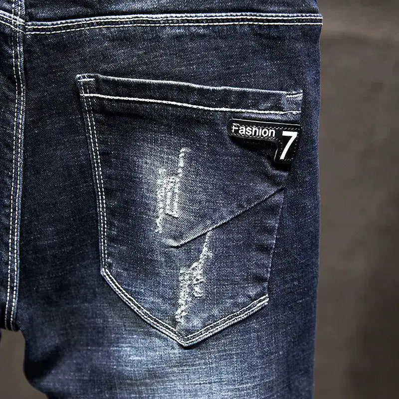 Men's blue cotton denim jeans with ripped back pocket and Fashion 7 label