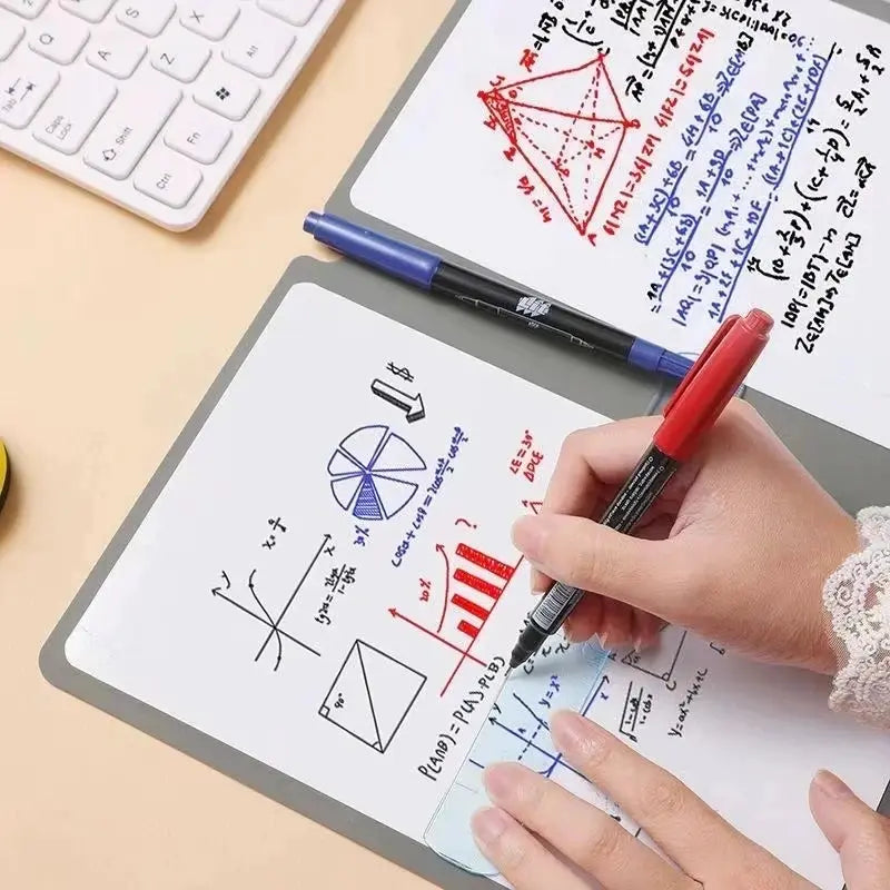 Two A5 reusable whiteboard notebooks by Simples Market with pens; portable weekly planners on desk
