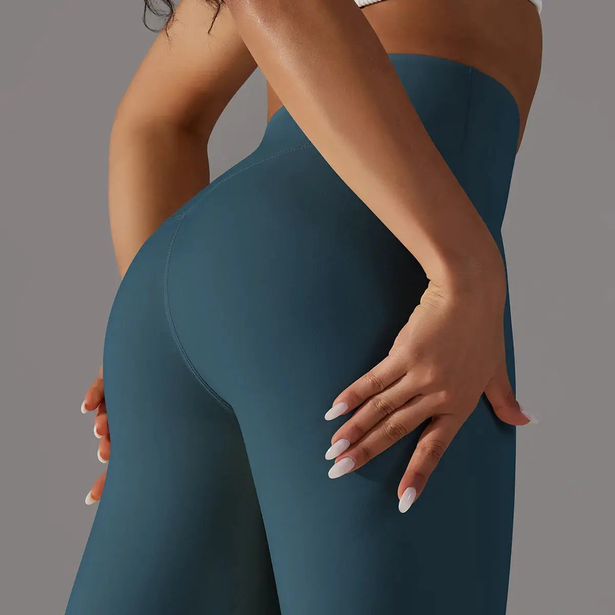 High-waisted teal leggings for fitness and yoga; close-up shows snug, smooth fit.