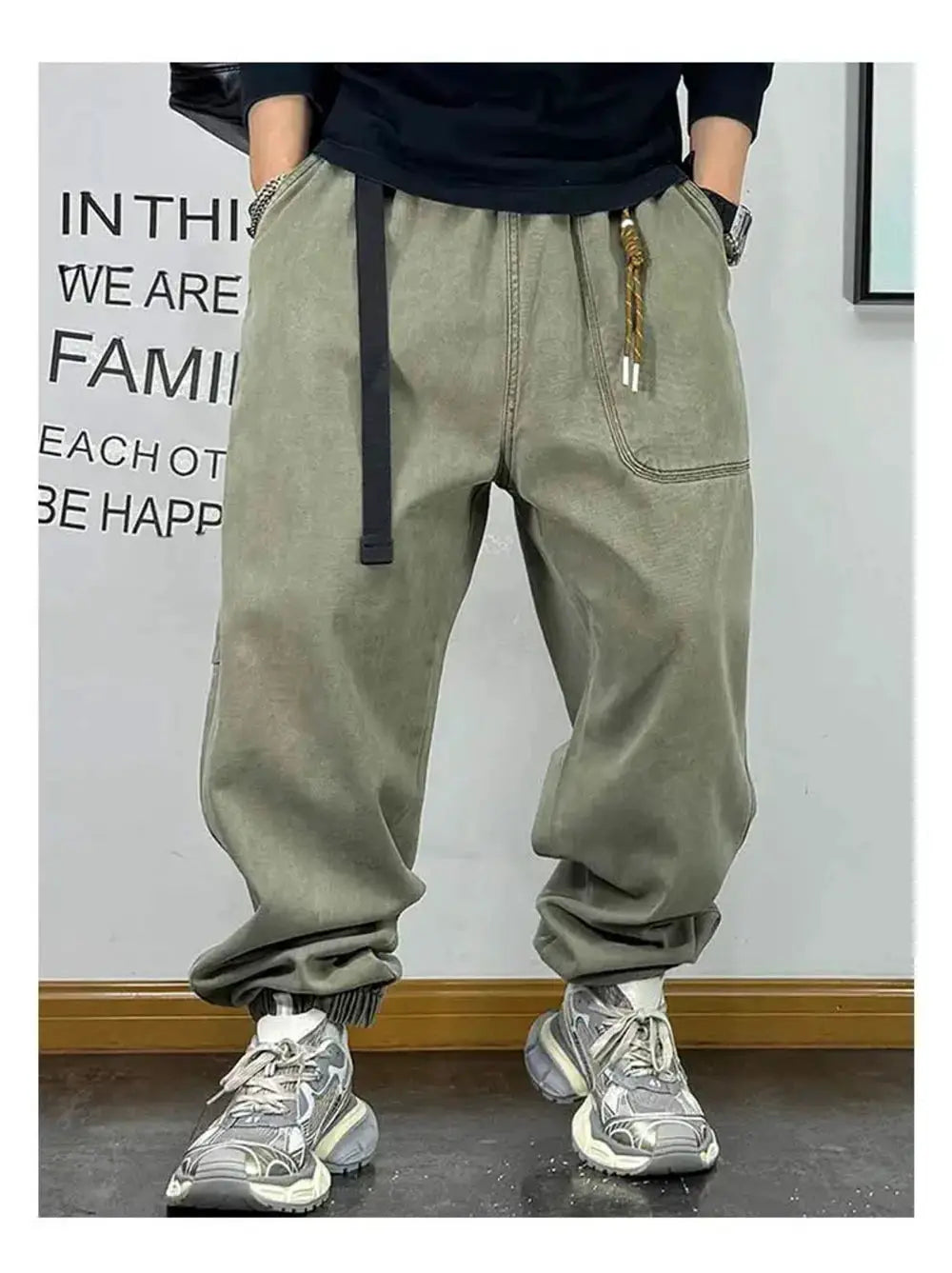 Olive green baggy cargo pants with oversized front pockets and rope drawstring, cuffed ankles