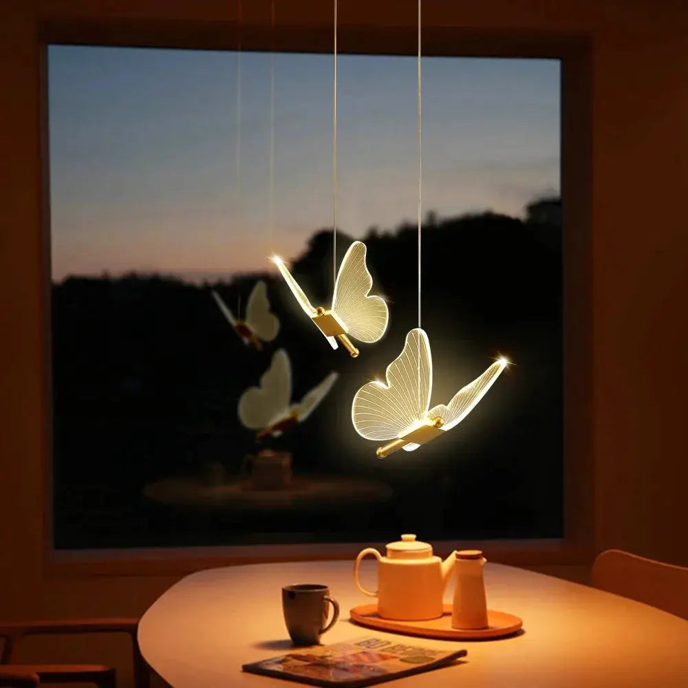 Simples Market LED modern butterfly pendant lights; three warm butterfly fixtures hanging over a dining table.