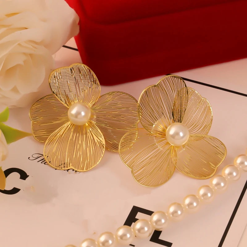 Pair of large flower pearl earrings by Simples Market; gold-tone petals with pearl centers