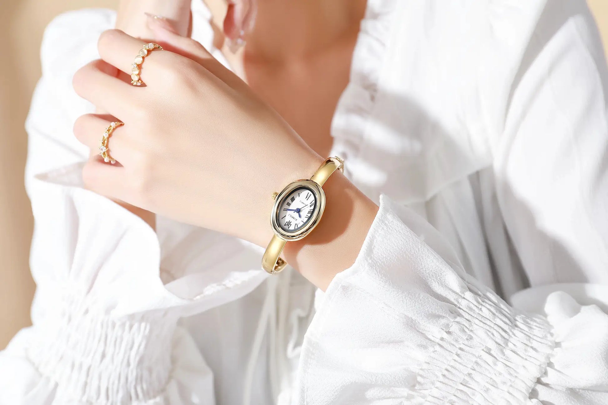Gold-tone women's quartz wristwatch with Roman numeral dial on a bracelet-style band