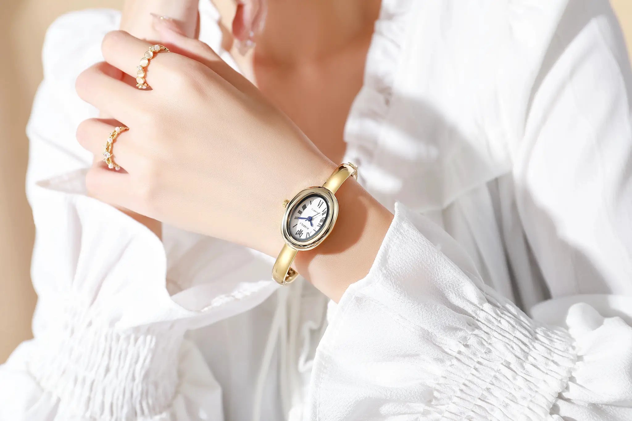 Gold-tone women's quartz wristwatch with Roman numeral dial on a bracelet-style band