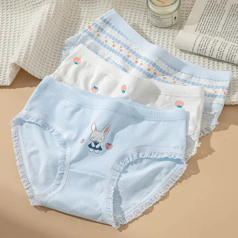 Three-pair cotton women's panties; pastel blue bunny print, white with strawberries, blue striped pattern.