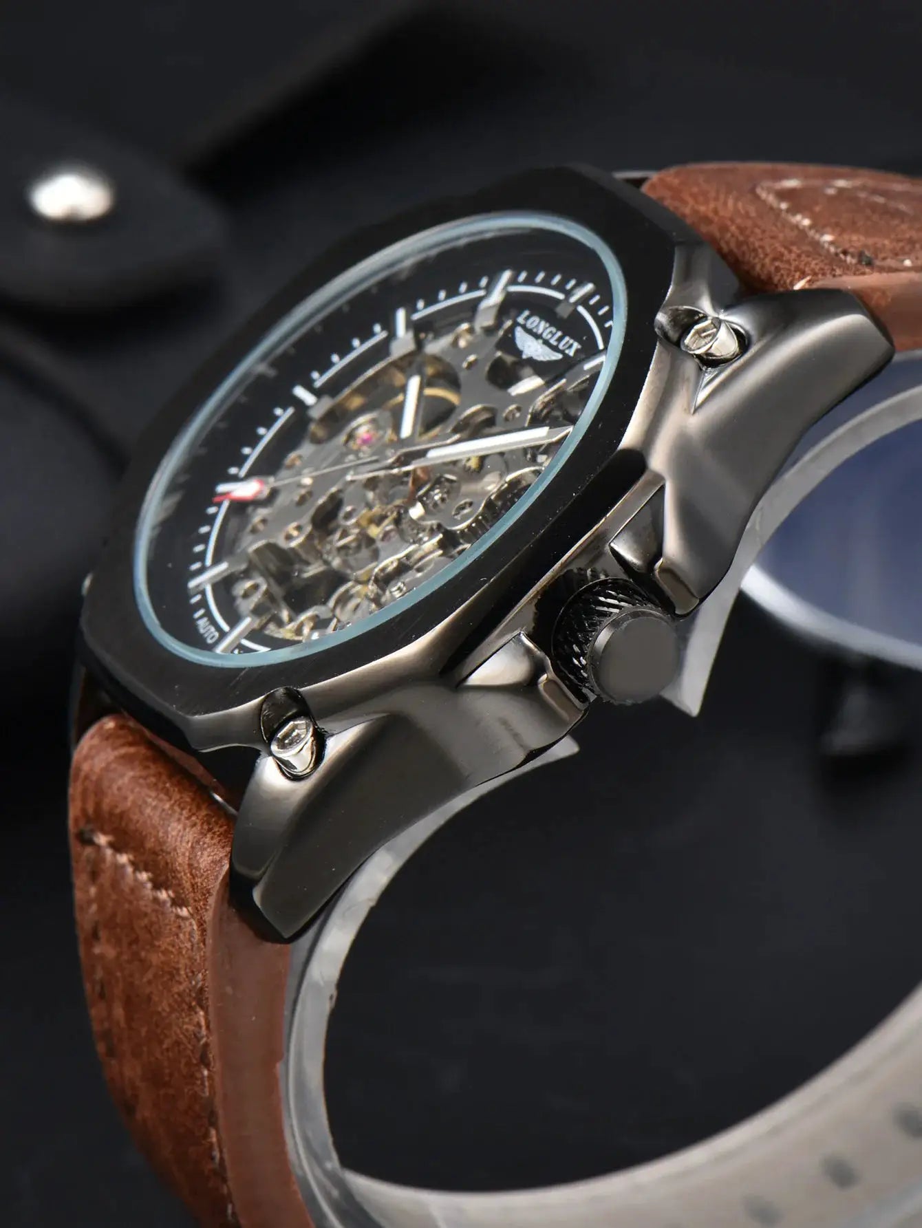 Men's automatic skeleton watch with visible gears, dark metal case and brown leather strap