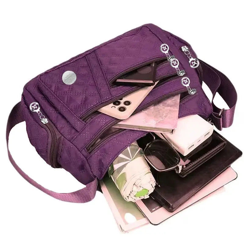 Purple quilted nylon handbag with crossbody strap and multiple compartments