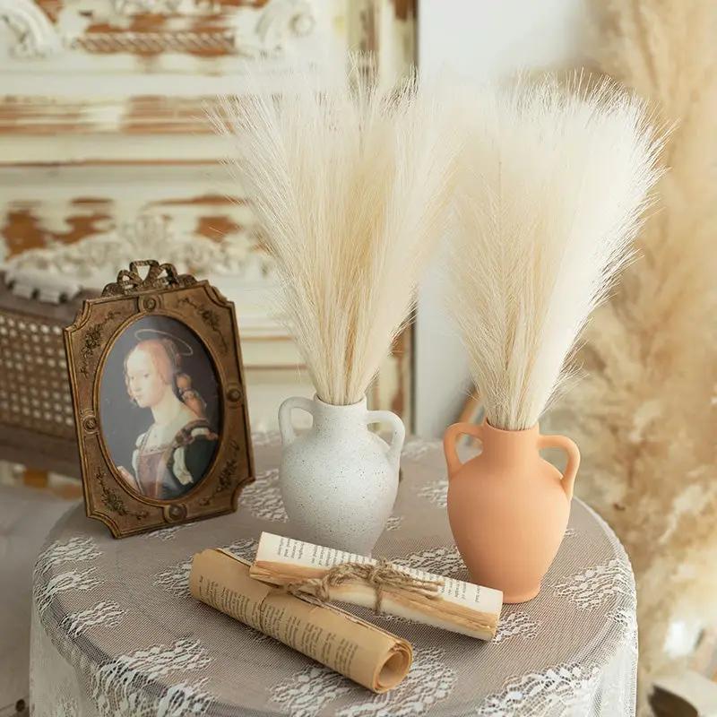 Artificial pampas grass bouquets in two vases, fluffy reed boho decor for table centerpiece