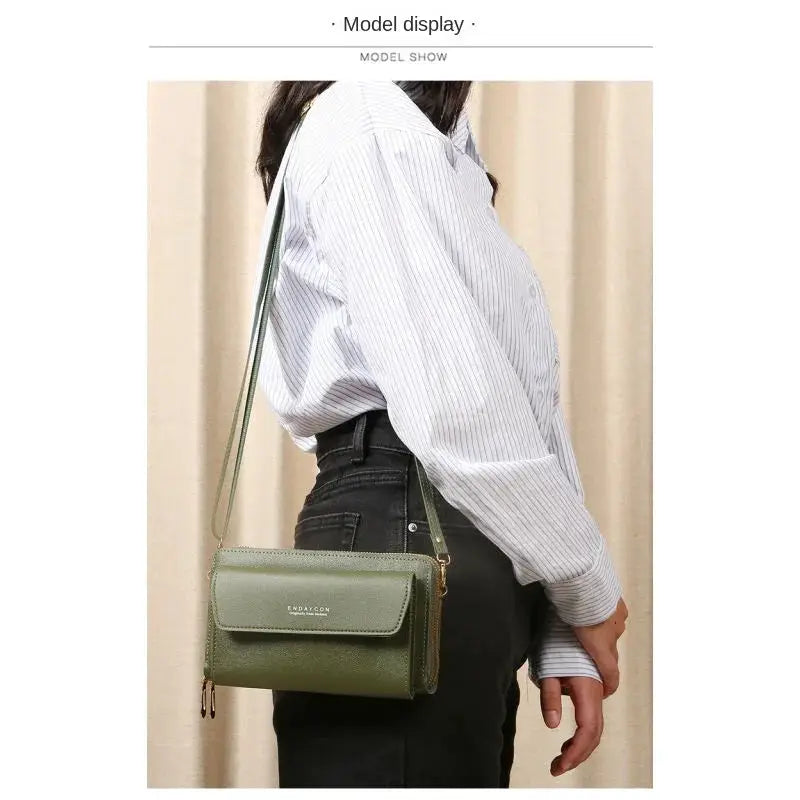 Crossbody bag Simples Market olive green with front flap and double zipper, worn on model.