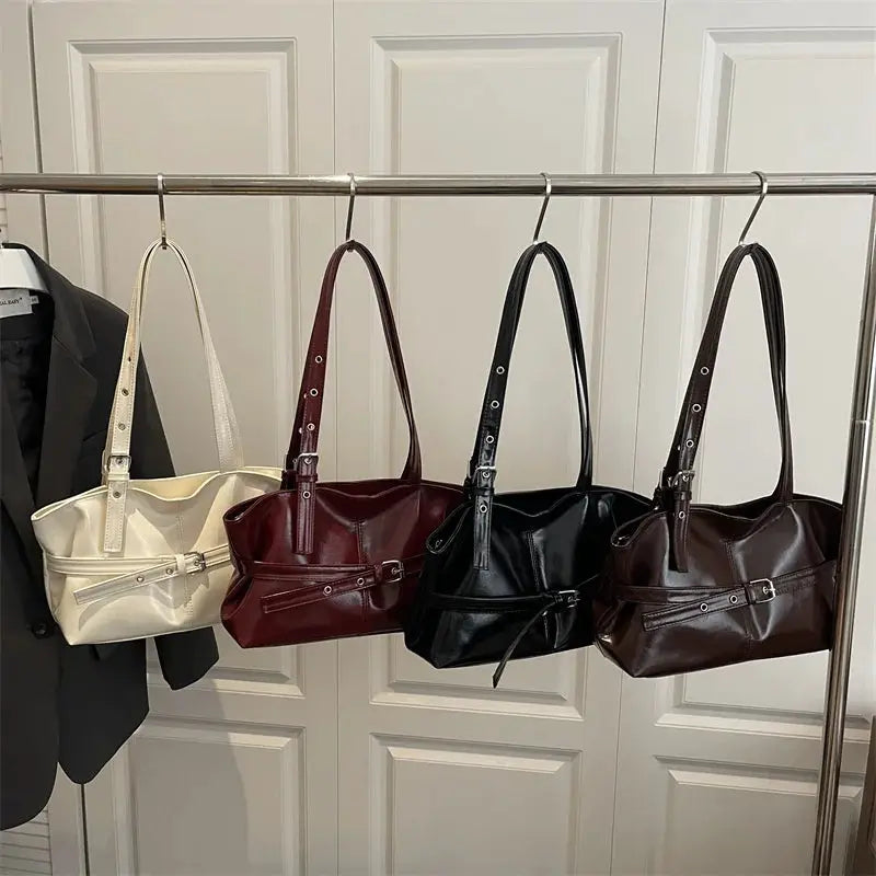Simples Market soft leather shoulder bag set of four in cream, burgundy, black, and brown with belt-buckle accents.
