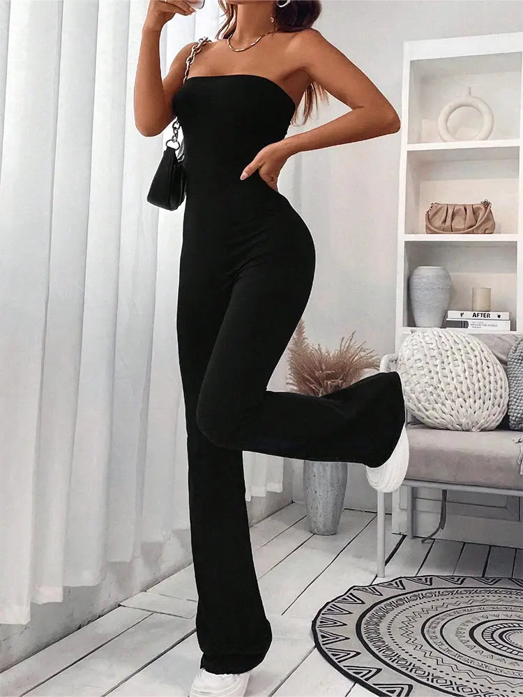 Women's black strapless jumpsuit with chain-strap detail and slim micro-flare pants.