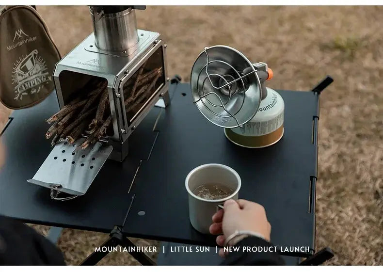 Mountainhiker portable mini sun gas heating stove on a camping table with gas canister, compact fan and mug