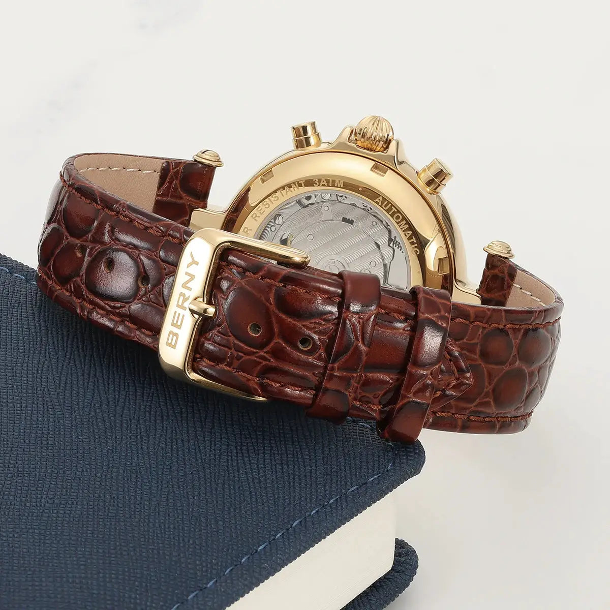 BERNY men's automatic watch with brown crocodile leather strap and gold-tone case, transparent back showing movement