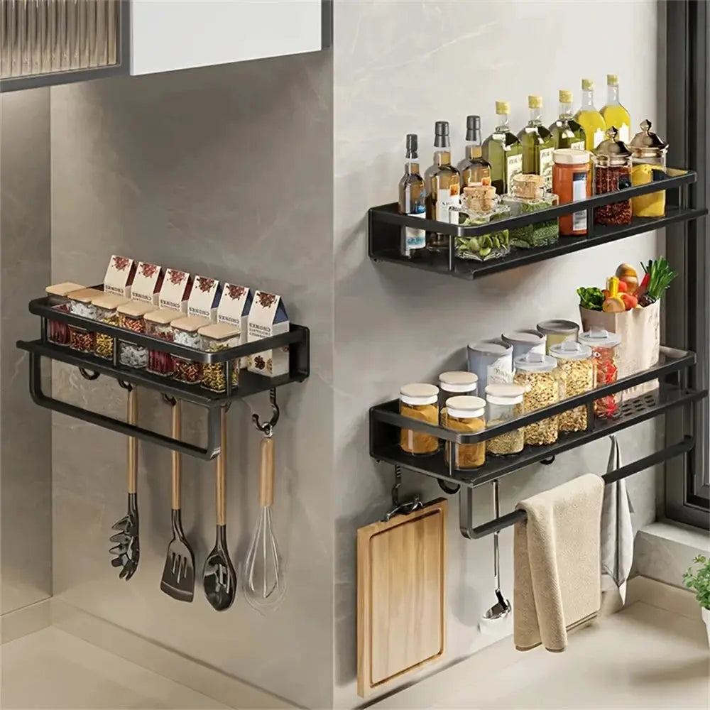 Two black wall-mounted storage racks for seasoning and cooking items, with jars, bottles, and utensils hooks