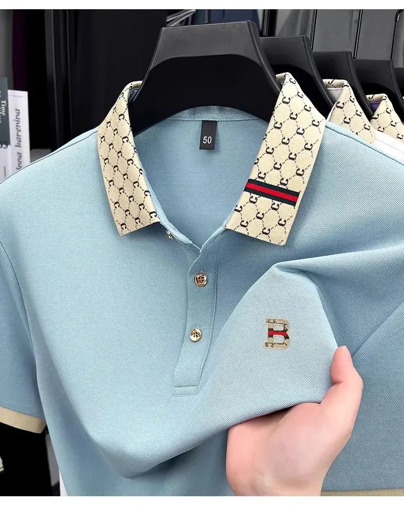 Men's blue short-sleeve polo shirt with beige patterned collar, gold buttons, and B emblem on chest