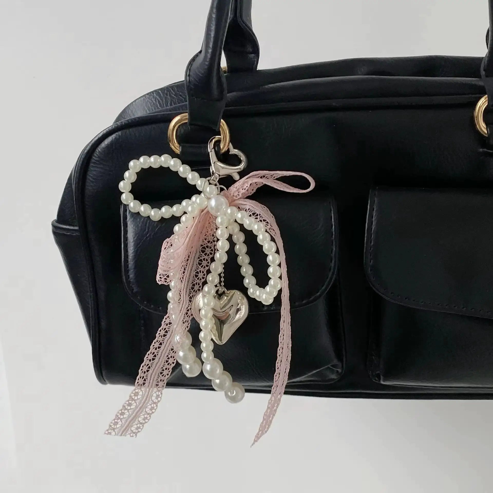 Y2K imitation pearl bead keychain with pink lace bow and heart charm on a black handbag