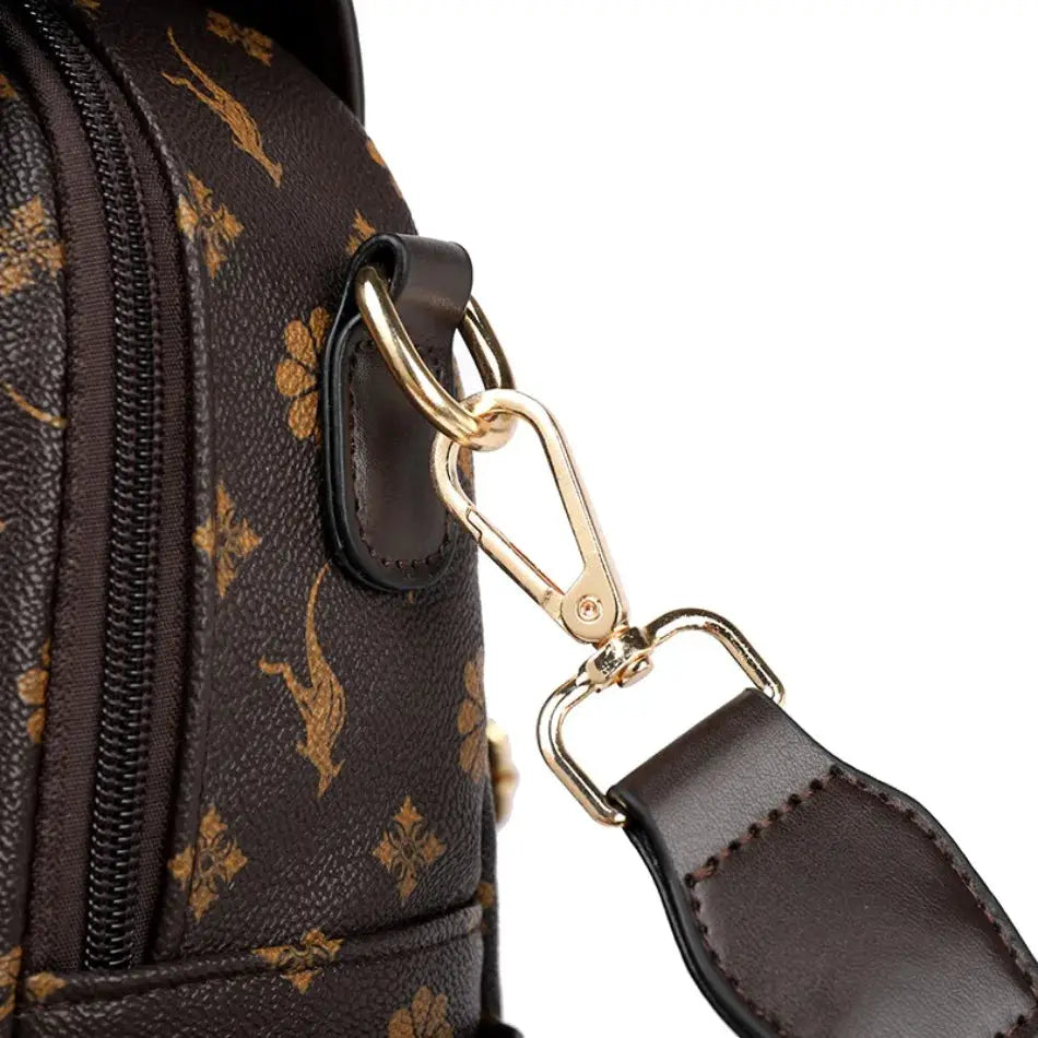 Brown leather ladies backpack with gold-tone hardware, monogram print, and detachable shoulder strap