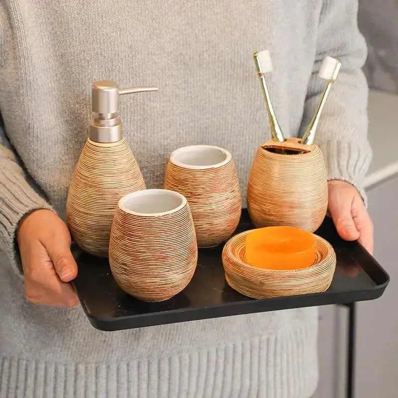 Cream ribbed ceramic bathroom set with pump dispenser, toothbrush holder, rinse cup and soap dish on a black tray
