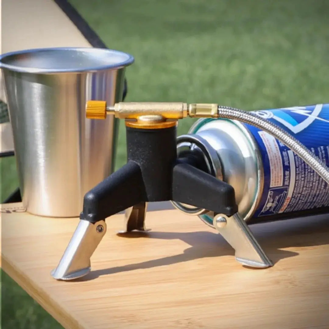 Camping gas stove adapter connector on a portable folding tripod stand with propane canister