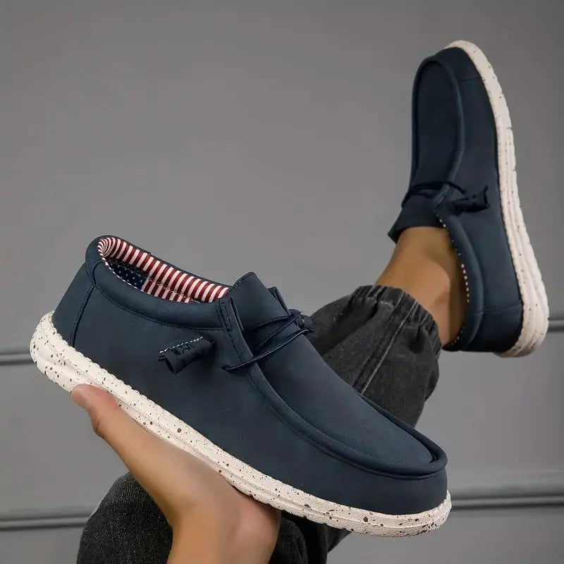 Men's navy blue loafers by Simples Market with speckled sole, tassel detail, striped lining.