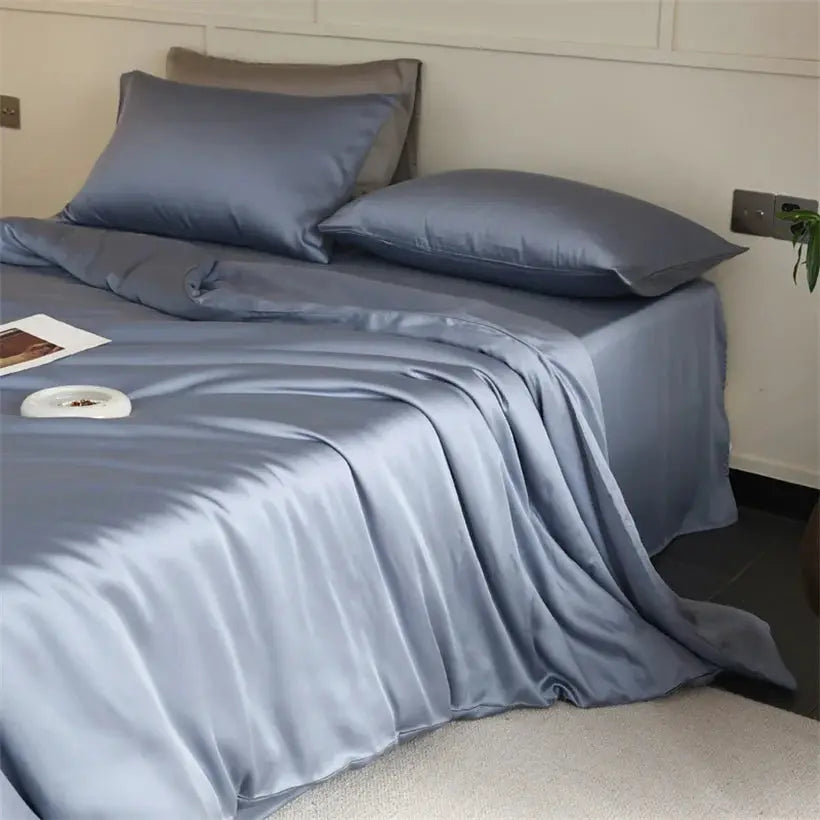 Mulberry Silk bedding set in blue, 100% silk, with two blue silk pillowcases and a matching duvet cover on a bed