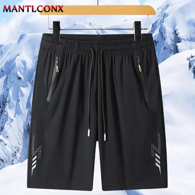 Men's black quick-dry sports shorts with elastic waist, drawstring, zip pockets, and MANTLCONX logo side prints.