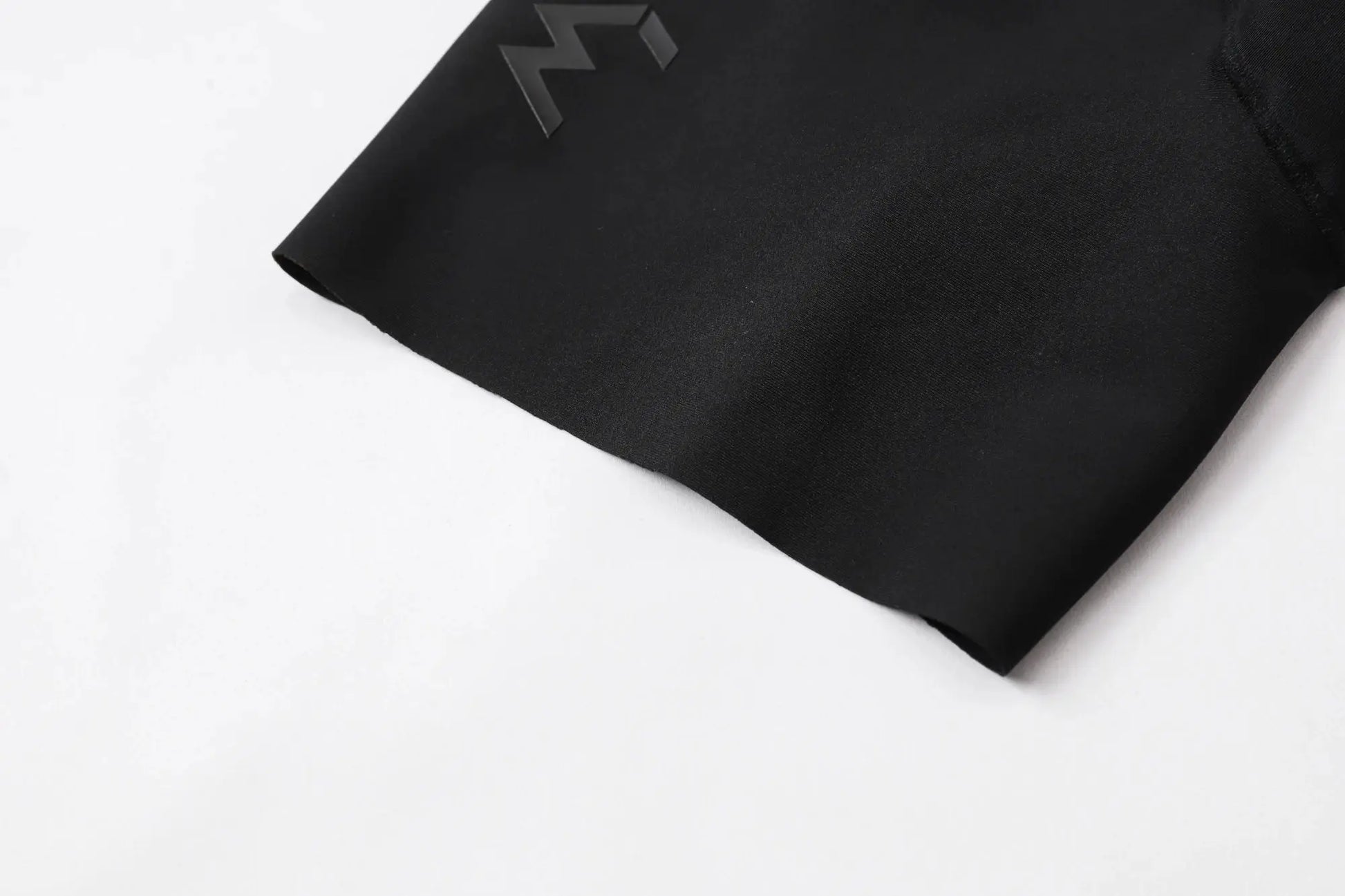 Cycling bib shorts in black with Simples Market logo, fabric close-up