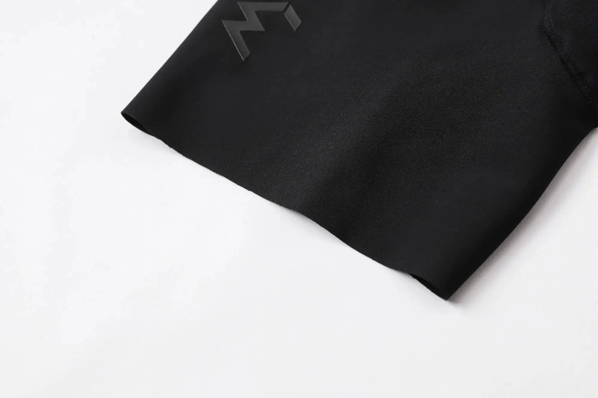 Cycling bib shorts in black with Simples Market logo, fabric close-up
