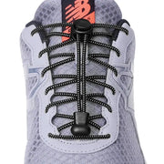 Elastic no-tie sneaker shoelaces with round black speckled cords and a cord lock; NB logo visible.