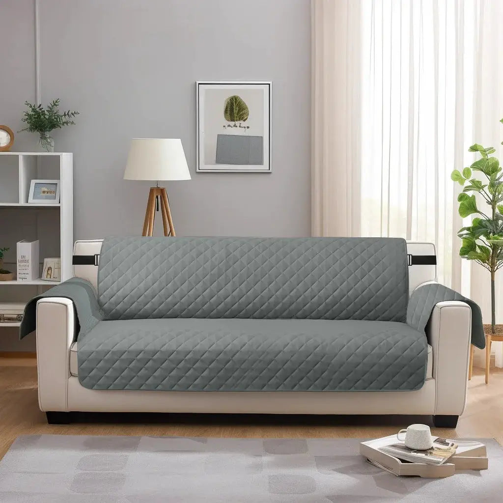 Sofa slipcover in gray quilted fabric for 3-seat sofa with elastic strap; waterproof and washable protector