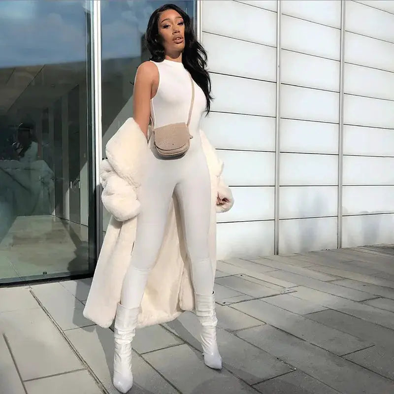 Pencil jumpsuit for women, white, sleeveless slim-fit activewear; model with beige crossbody bag and white coat