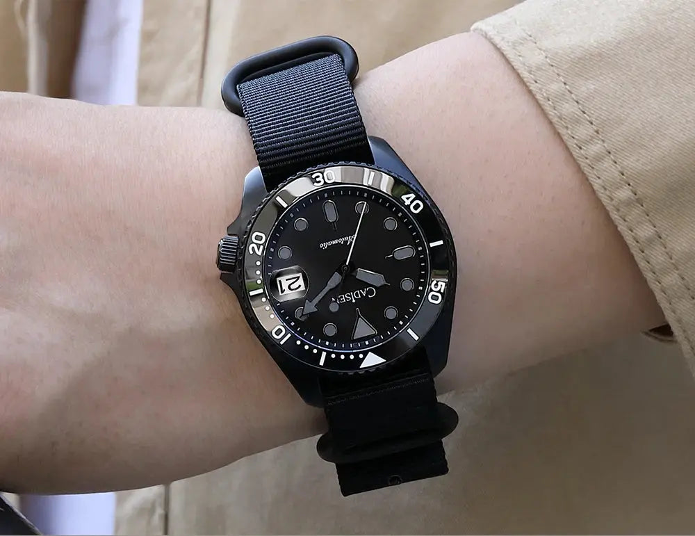 CADISEN men's mechanical wristwatch with black ceramic bezel and sapphire glass on a black NATO strap.