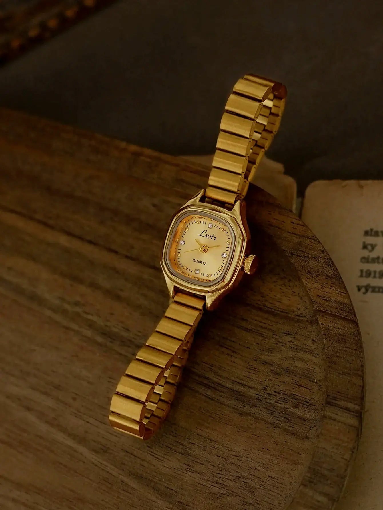 Gold-tone square-dial women's watch with a stainless steel bracelet and quartz movement