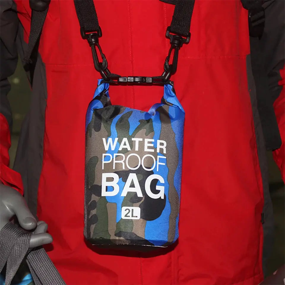 Waterproof dry bag 2L in blue camouflage hanging from a red outdoor jacket