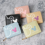 Five zip wallets in black, pink, beige, light blue, and pale yellow with white Mickey silhouette, Hello, glitter accent.