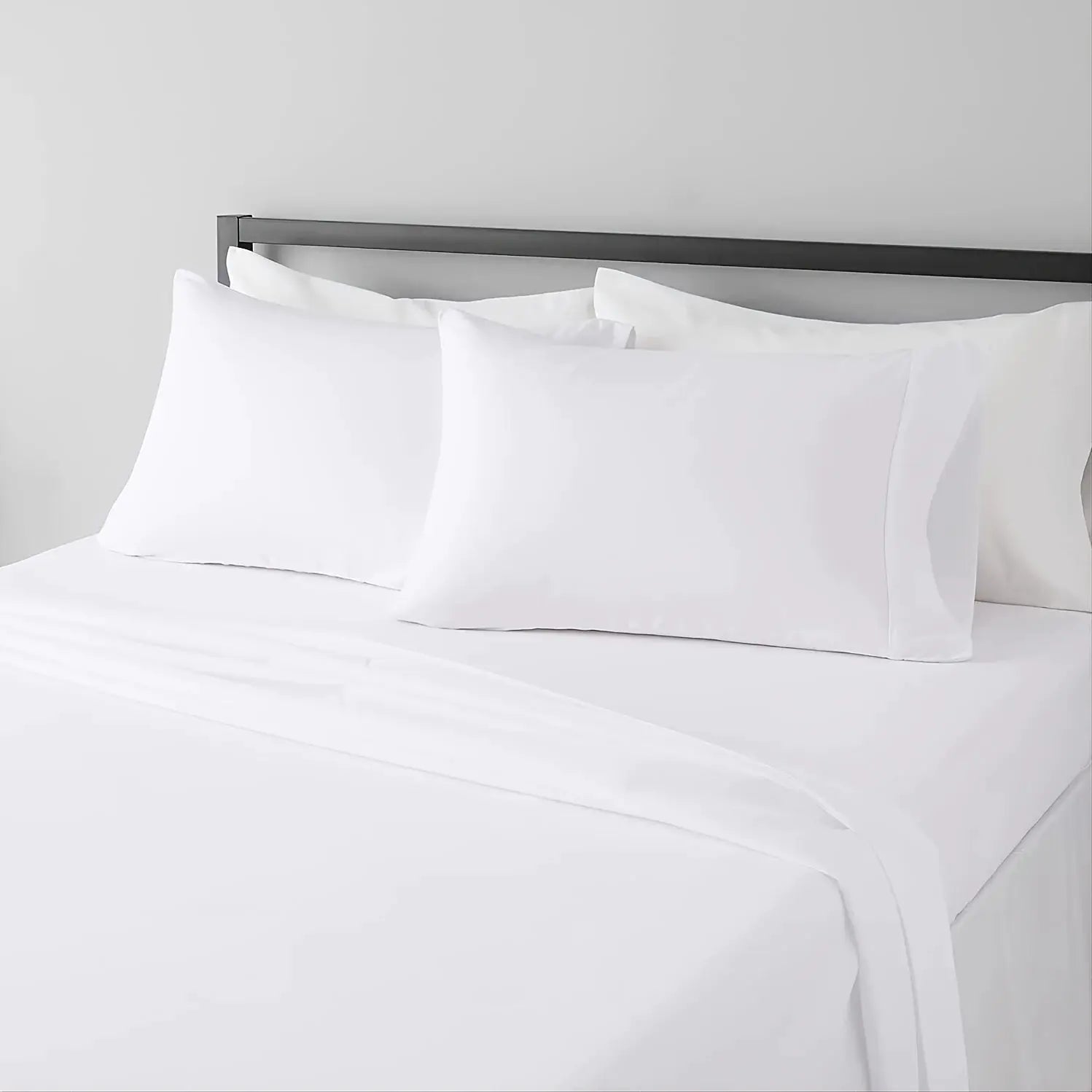 Sheet set on white bed with white pillowcases; breathable cooling hotel-style sheets