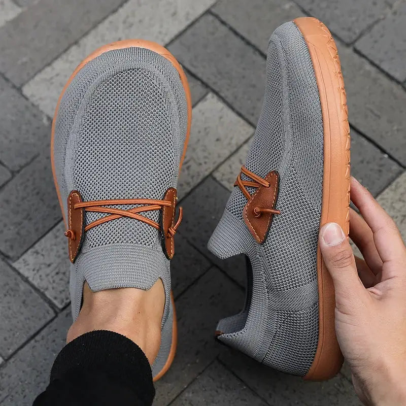Pair of gray wide-version barefoot minimalist shoes with tan outsole and brown leather lace accents