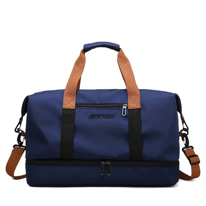 Large navy blue travel gym bag with tan handles, detachable shoulder strap, and dual zippers