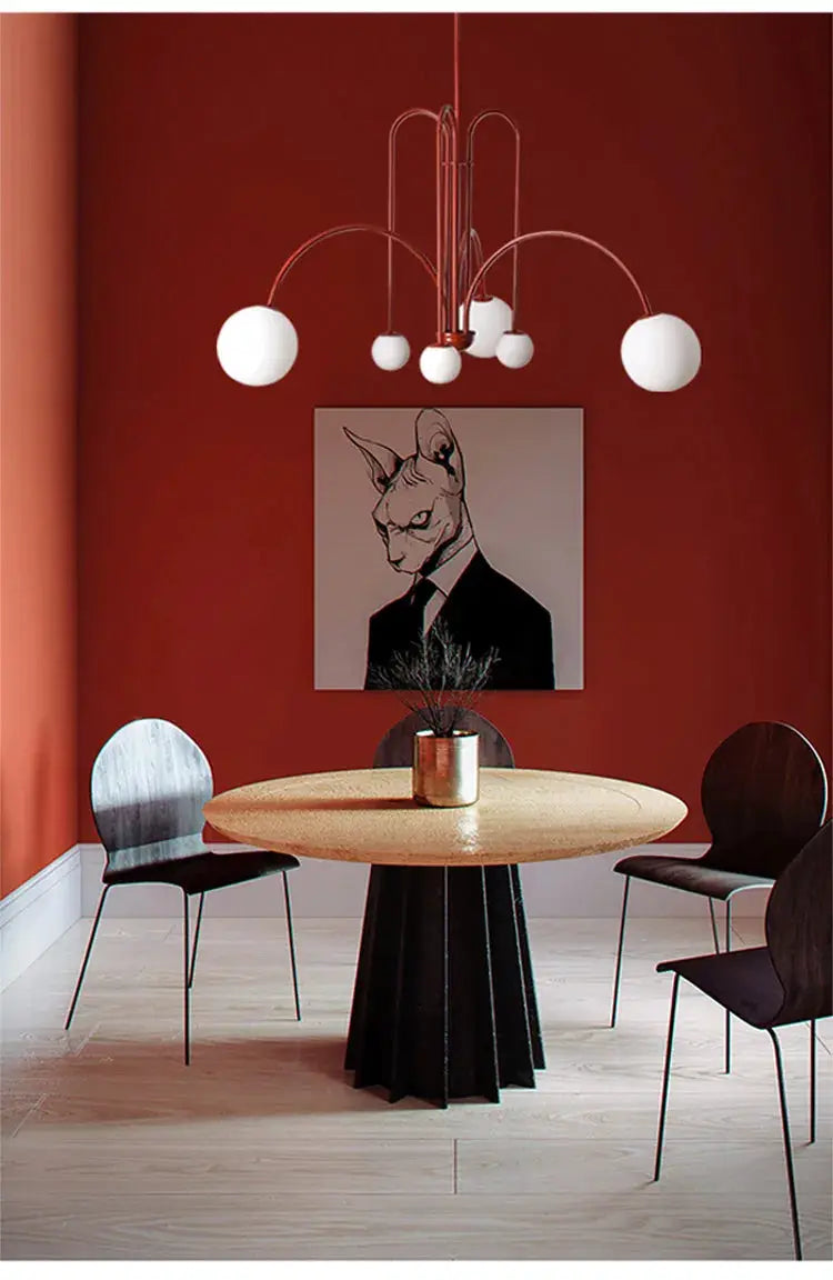Nordic minimalist pendant light with copper arches and white globe bulbs over a round wooden dining table.