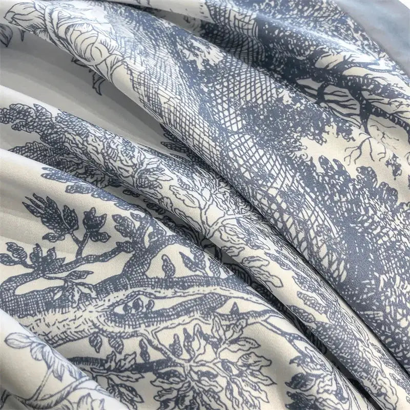 Lyocell bedding set with blue botanical print on white fabric; duvet cover, sheets, and pillowcases.