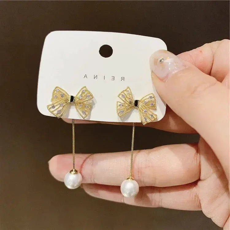 Pair of punk geometric zinc alloy bow earrings with crystal accents and pearl drops