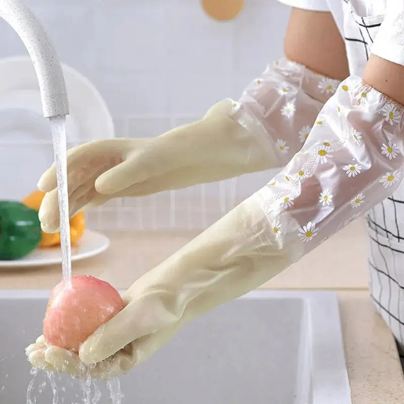 Floral-pattern latex waterproof cleaning gloves for kitchen use, worn while washing a pink apple at the sink
