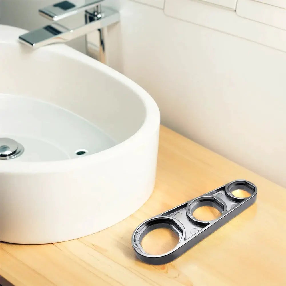 Simples Market 6-in-1 faucet wrench tool, gray plastic, on wooden counter beside sink